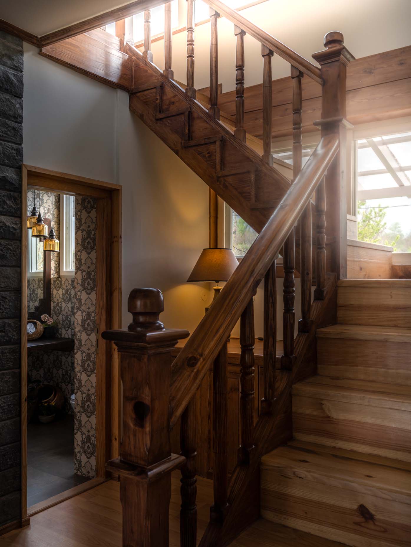 A grand wooden staircase, basking in the glow of a gentle light streaming through a window